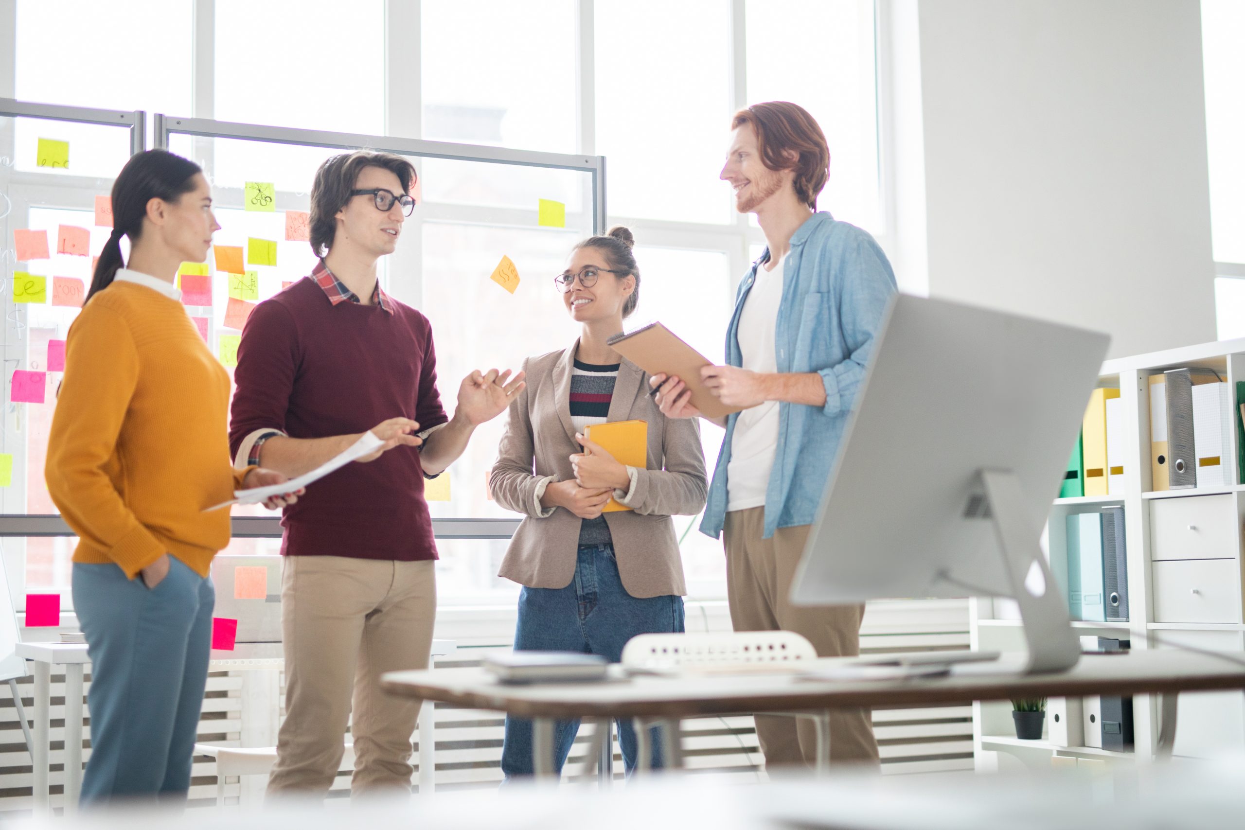 four young casual colleagues brainstorming and discussing