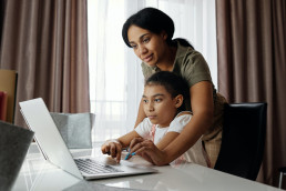 mom helping child on computer
